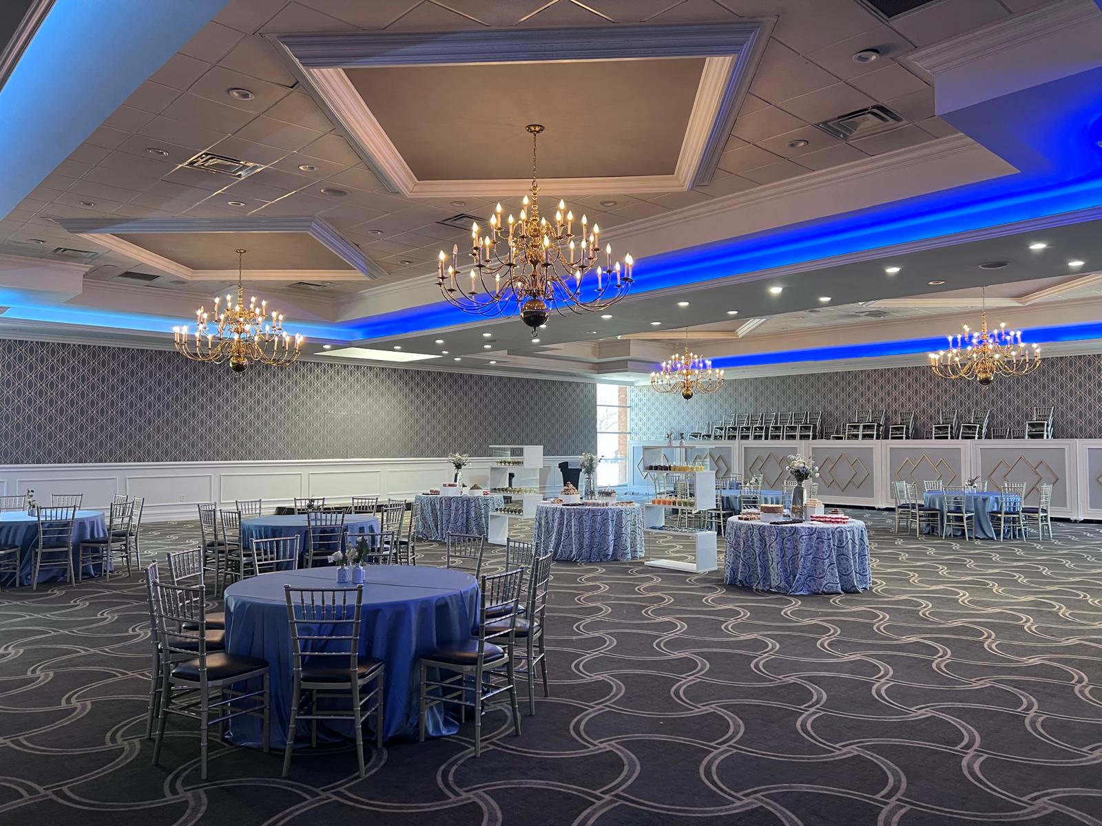 Elegant ballroom set with chandeliers and blue uplighting